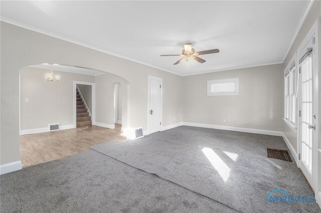 carpeted empty room featuring crown molding and ceiling fan with notable chandelier