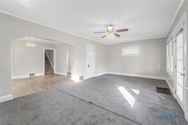 carpeted spare room featuring crown molding and ceiling fan with notable chandelier