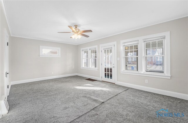 carpeted spare room featuring ornamental molding and ceiling fan