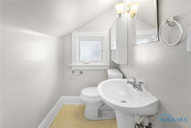 bathroom with lofted ceiling, sink, and toilet