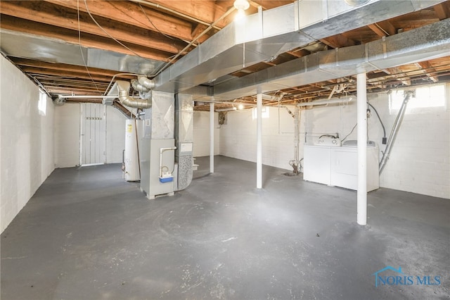 basement featuring gas water heater, heating unit, and washer and clothes dryer