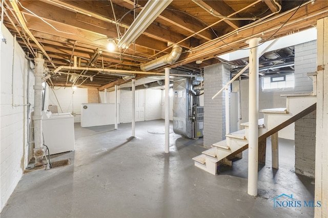 basement featuring heating unit, washing machine and dryer, and water heater