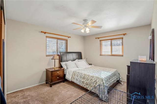 bedroom with ceiling fan, light colored carpet, and multiple windows