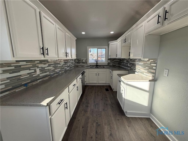 kitchen featuring sink, white cabinetry, tasteful backsplash, stainless steel dishwasher, and dark hardwood / wood-style flooring