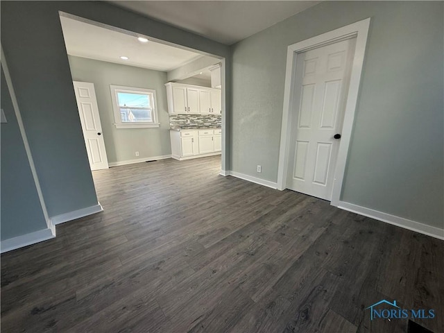 unfurnished living room with dark hardwood / wood-style flooring