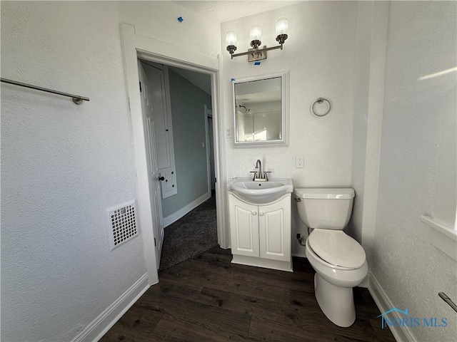 bathroom with vanity, hardwood / wood-style flooring, and toilet