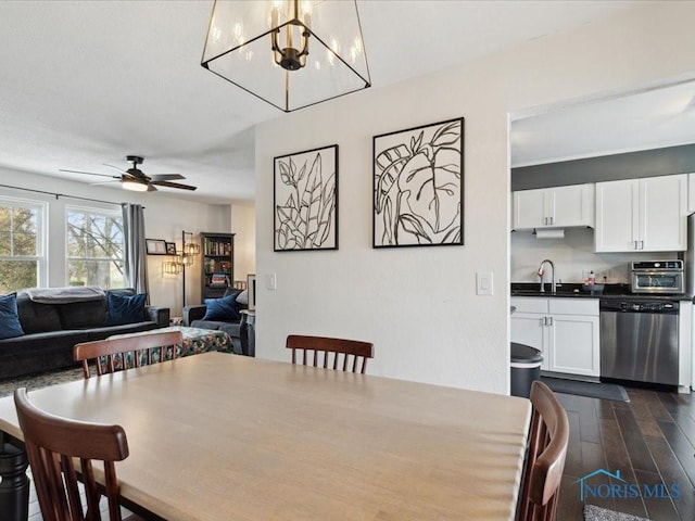 dining area with ceiling fan with notable chandelier, dark hardwood / wood-style floors, and sink