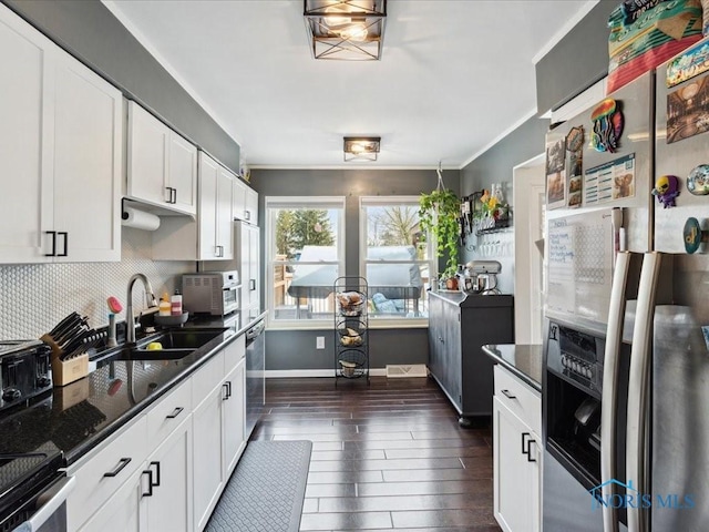 kitchen with white cabinetry, sink, dark hardwood / wood-style flooring, dark stone counters, and stainless steel appliances