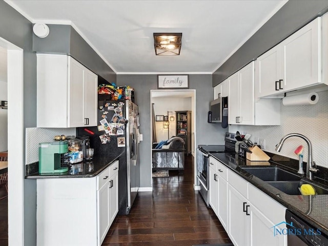 kitchen featuring dark stone countertops, appliances with stainless steel finishes, sink, and white cabinets