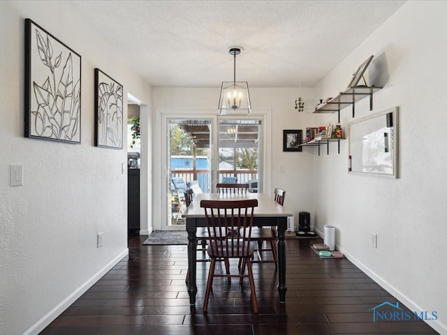 dining space featuring dark hardwood / wood-style floors and a chandelier