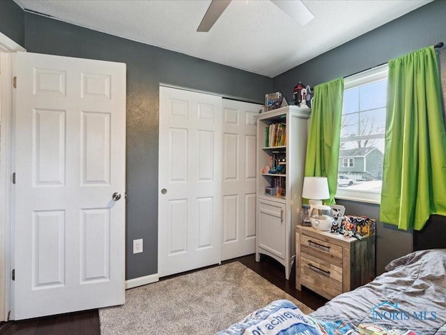 bedroom with dark hardwood / wood-style floors, ceiling fan, and a closet