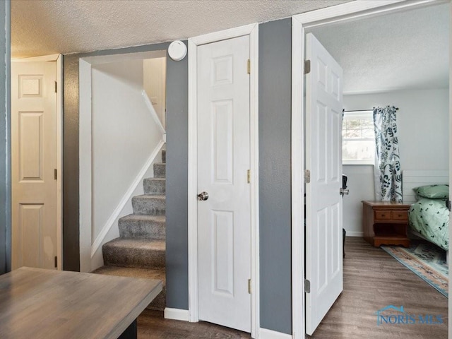 stairway featuring hardwood / wood-style flooring and a textured ceiling