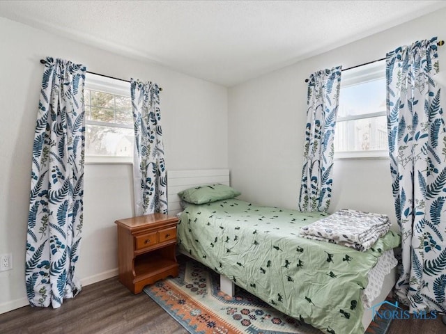 bedroom with dark hardwood / wood-style flooring