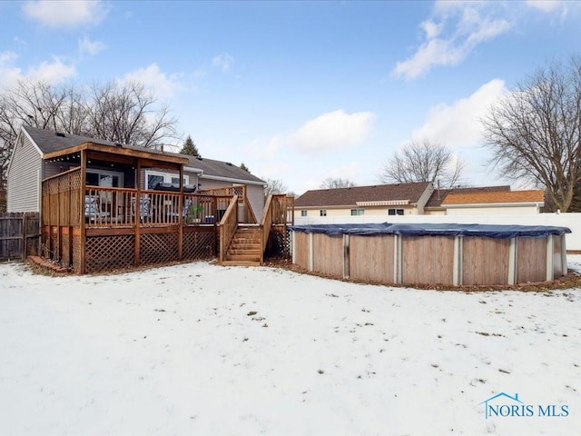 snow covered property with a pool side deck