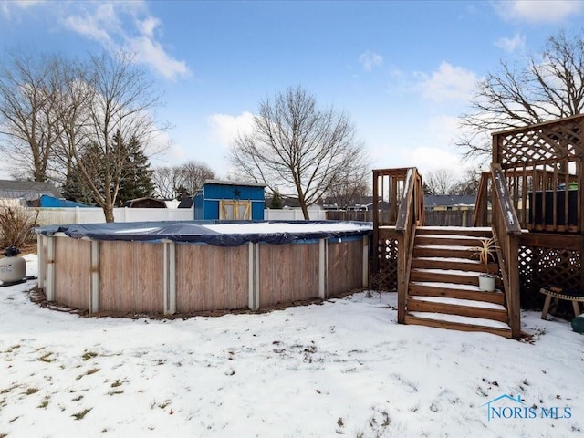 yard covered in snow with a swimming pool side deck