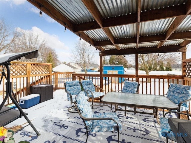 snow covered deck with a storage unit