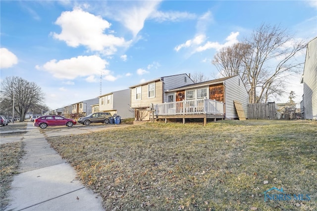 view of front of home featuring a deck and a front lawn