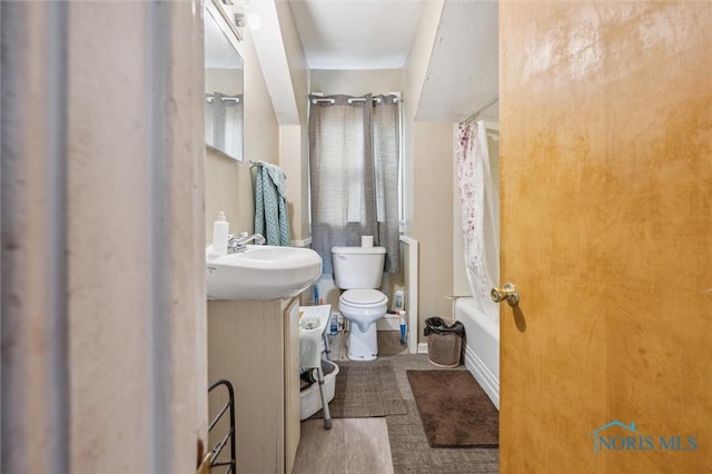 full bathroom featuring sink, shower / tub combo, and toilet