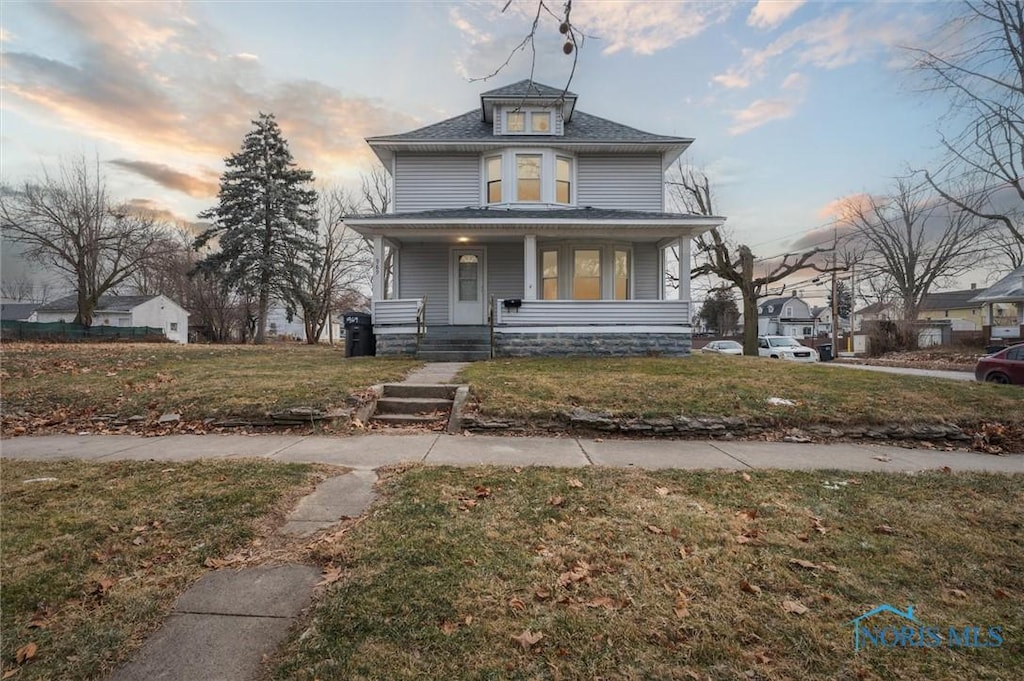 view of front of property featuring a porch and a yard