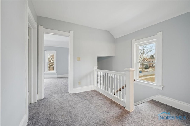 hallway with vaulted ceiling and carpet floors