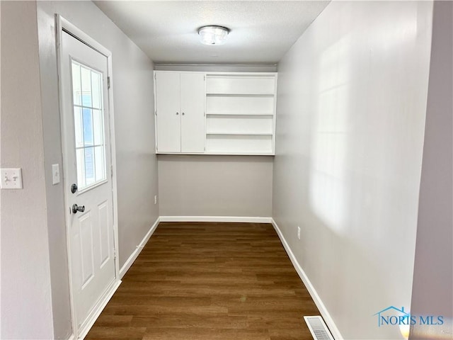 entryway featuring dark wood-type flooring and a textured ceiling