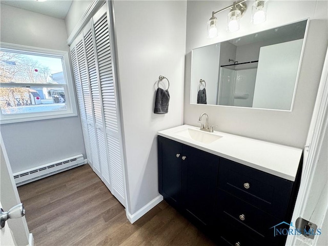 bathroom featuring baseboard heating, vanity, and hardwood / wood-style floors