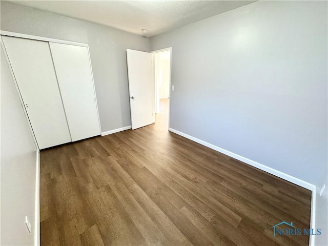 unfurnished bedroom featuring hardwood / wood-style floors and a closet