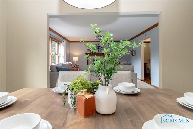 dining area with crown molding and wood-type flooring