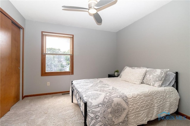 carpeted bedroom with ceiling fan and a closet