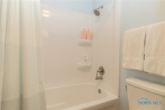 bathroom featuring shower / bathtub combination with curtain and toilet