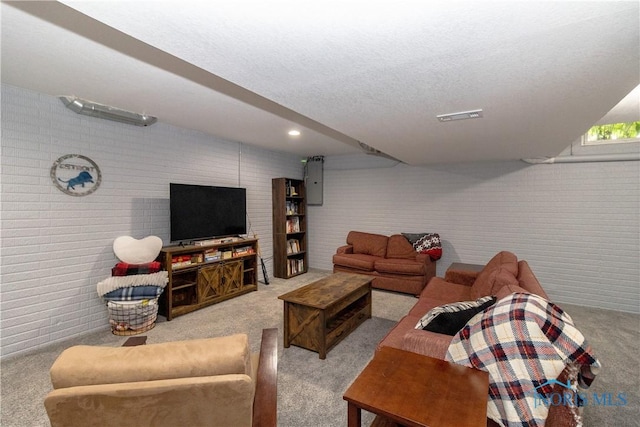 carpeted living room featuring brick wall