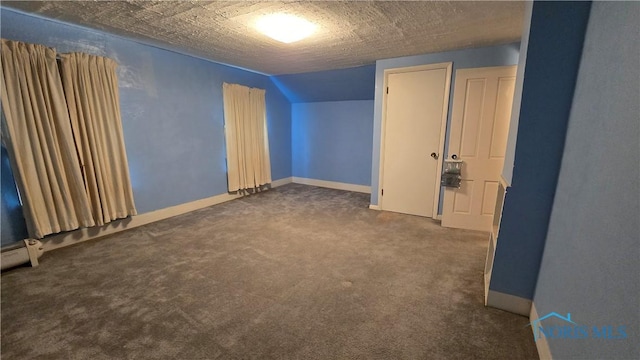 carpeted spare room featuring lofted ceiling and a textured ceiling