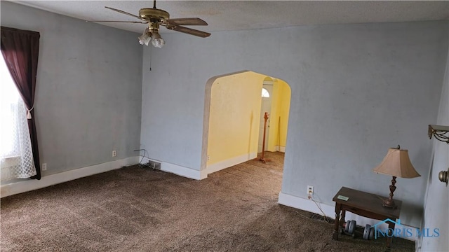 unfurnished room with ceiling fan, carpet flooring, and a textured ceiling