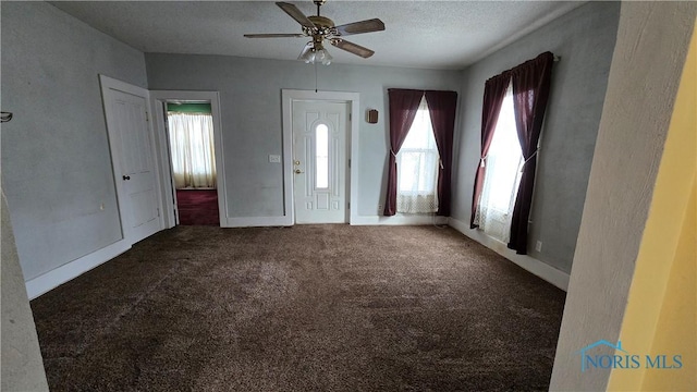 carpeted foyer entrance featuring a textured ceiling and ceiling fan