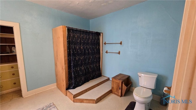 bathroom featuring curtained shower and toilet