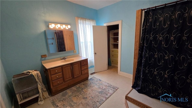 bathroom featuring vanity, a fireplace, and heating unit