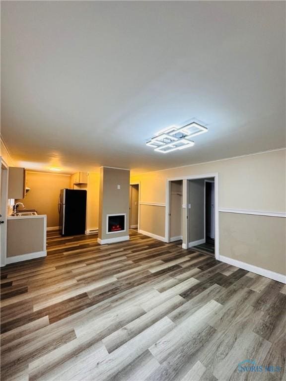 unfurnished living room featuring sink and wood-type flooring