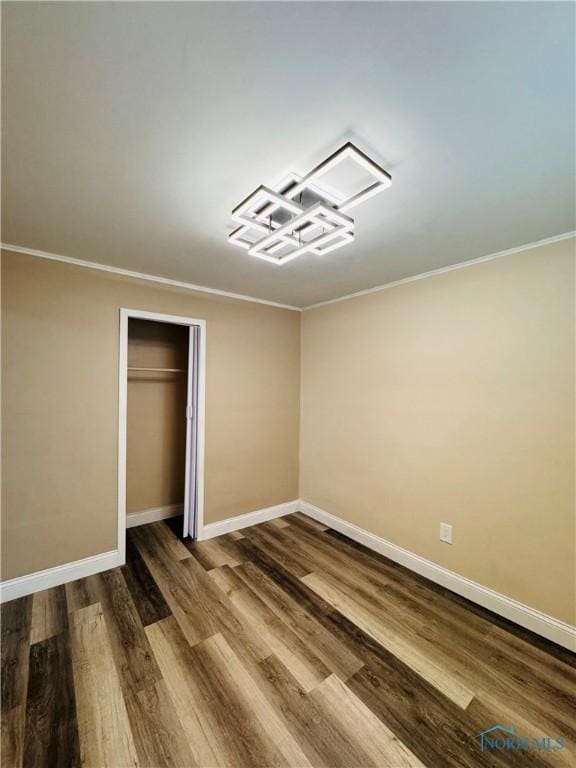 unfurnished bedroom featuring crown molding, hardwood / wood-style floors, and a closet