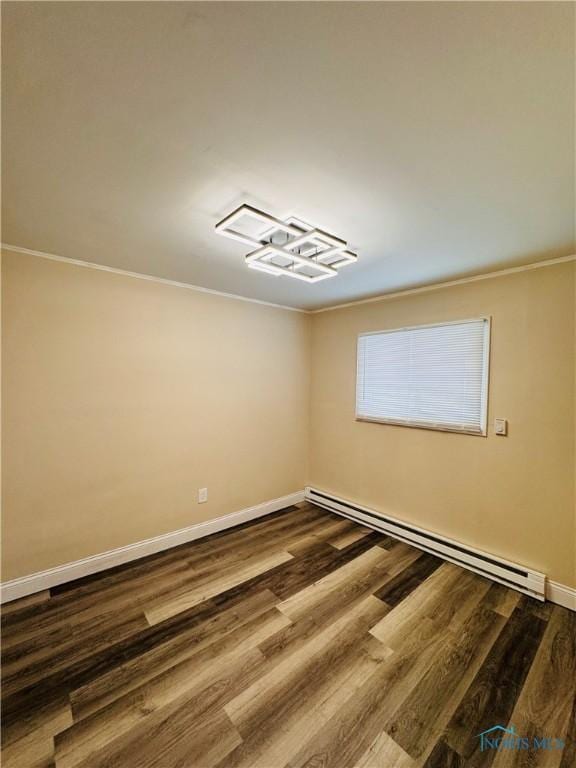 unfurnished room featuring hardwood / wood-style flooring, crown molding, and a baseboard heating unit