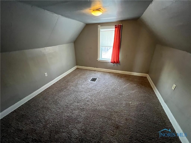 additional living space featuring vaulted ceiling and carpet