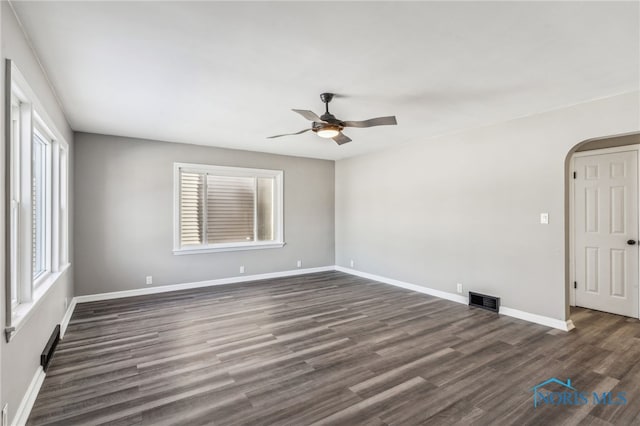 spare room featuring plenty of natural light, dark hardwood / wood-style floors, and ceiling fan