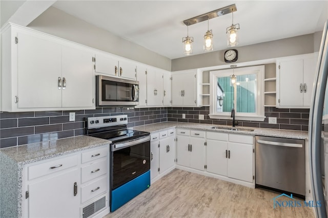 kitchen featuring sink, stainless steel appliances, hanging light fixtures, and white cabinets