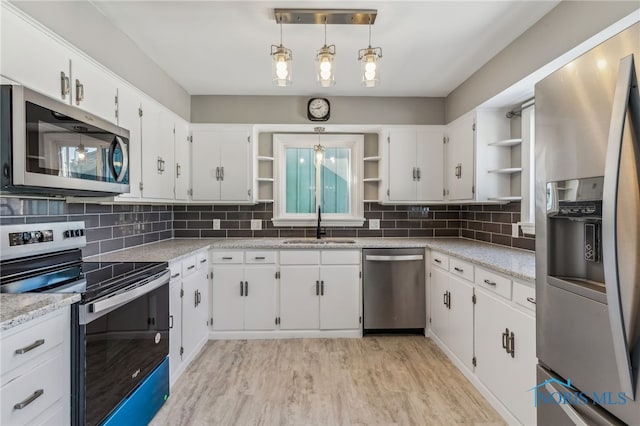 kitchen with white cabinetry, hanging light fixtures, backsplash, and stainless steel appliances