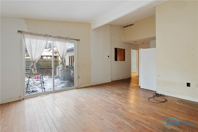 unfurnished room featuring vaulted ceiling with beams and hardwood / wood-style flooring