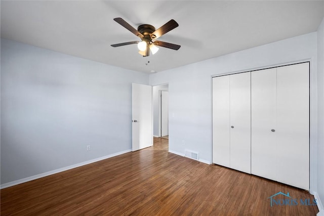 unfurnished bedroom with hardwood / wood-style floors, a closet, and ceiling fan