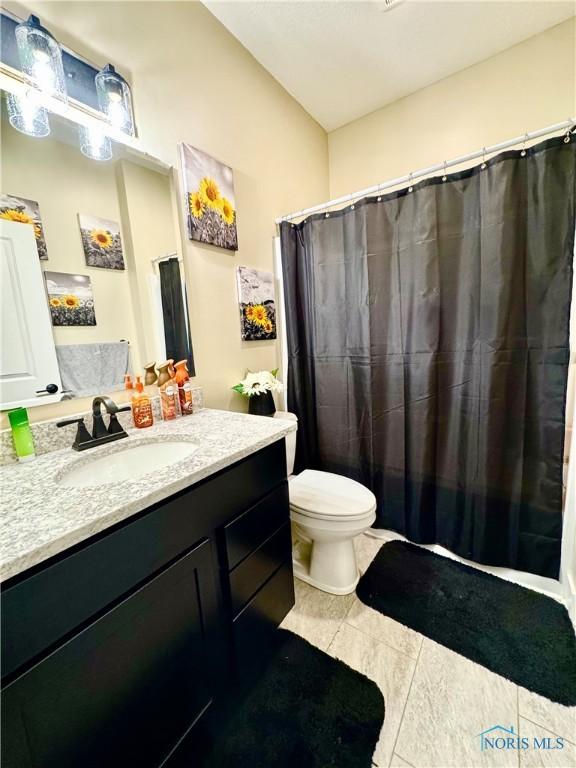 bathroom featuring vanity, tile patterned floors, and toilet