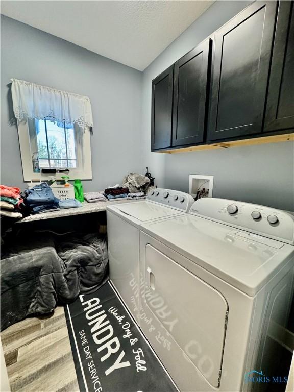 washroom featuring cabinets, separate washer and dryer, and hardwood / wood-style floors