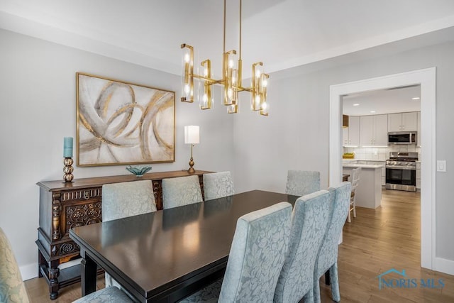 dining space with an inviting chandelier and light hardwood / wood-style floors