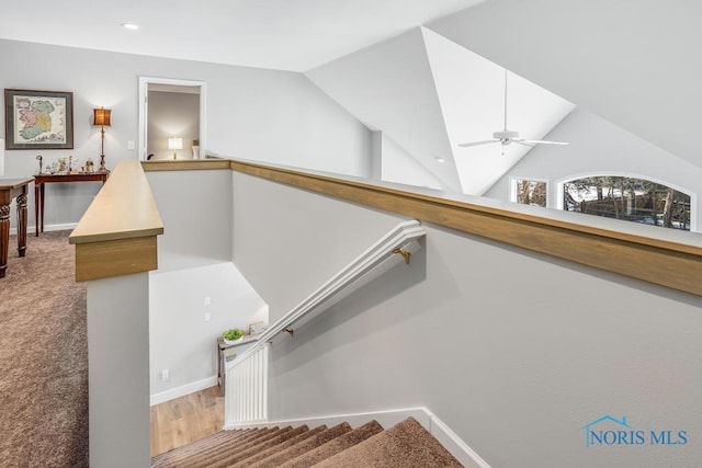 stairway featuring vaulted ceiling and ceiling fan