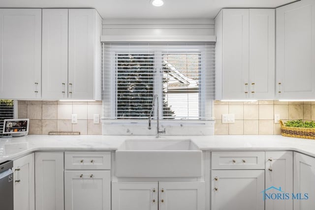 kitchen featuring backsplash, dishwasher, sink, and white cabinets